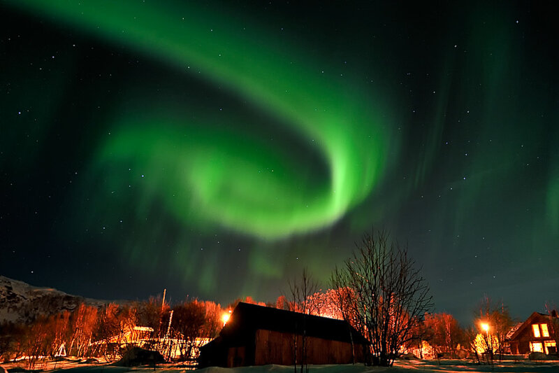 Northern Lights over a snowy village