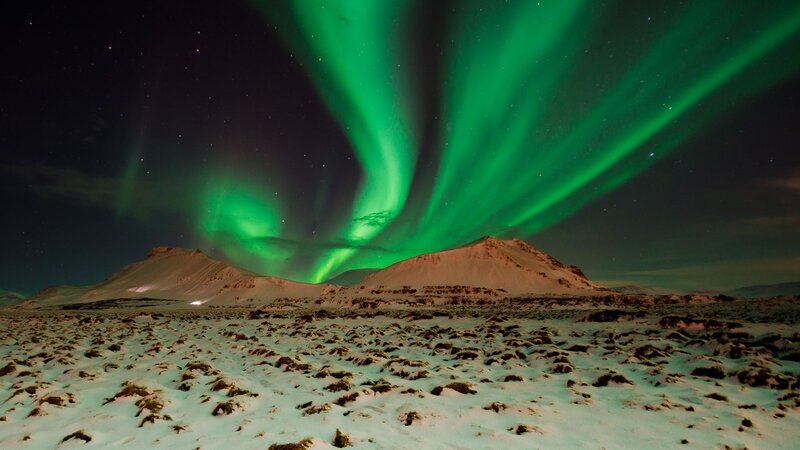 Northern Lights over snowy mountains