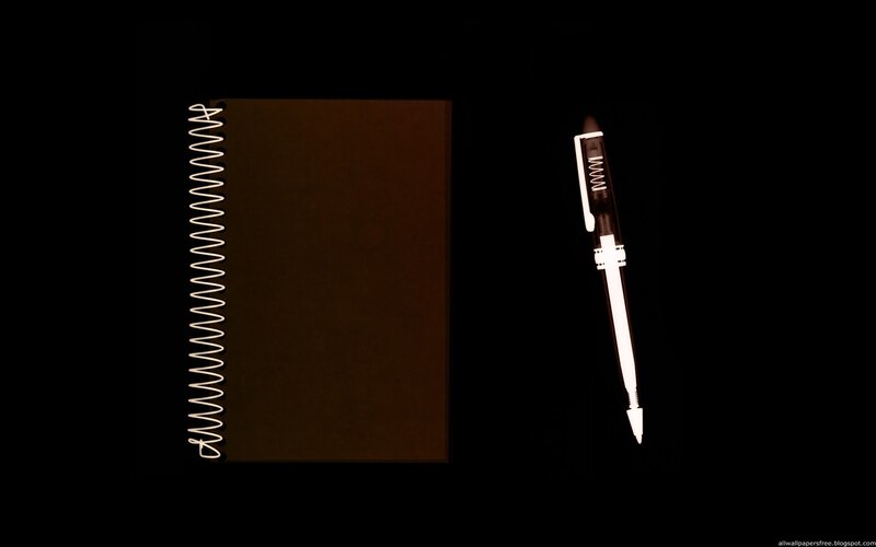 notebook and pen on black