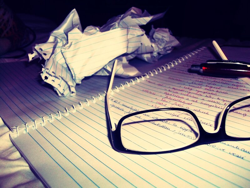 Notebook with glasses and crumpled paper