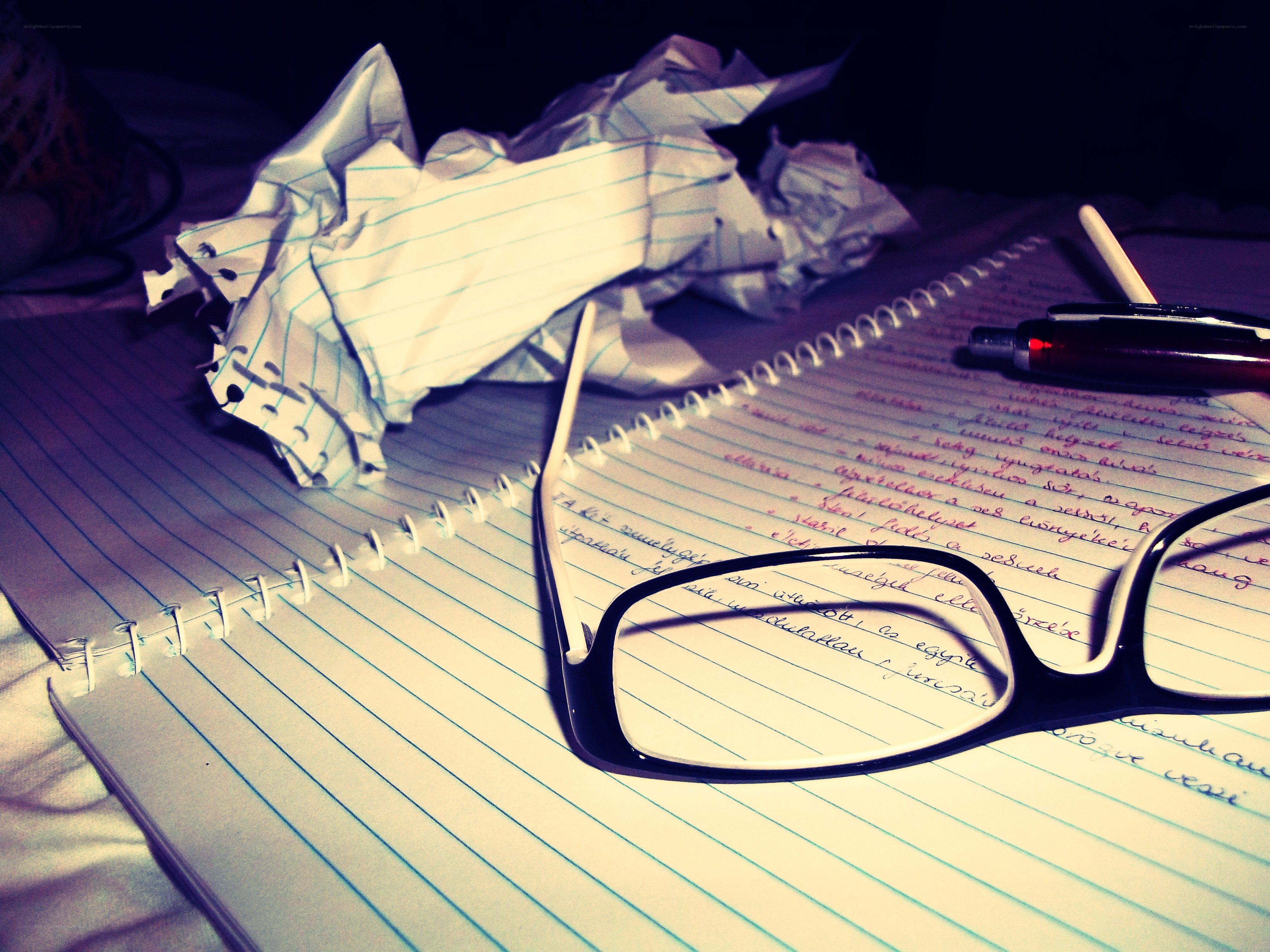 Notebook with glasses and crumpled paper