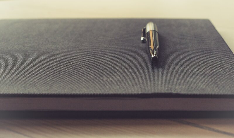 notebook with pen on table