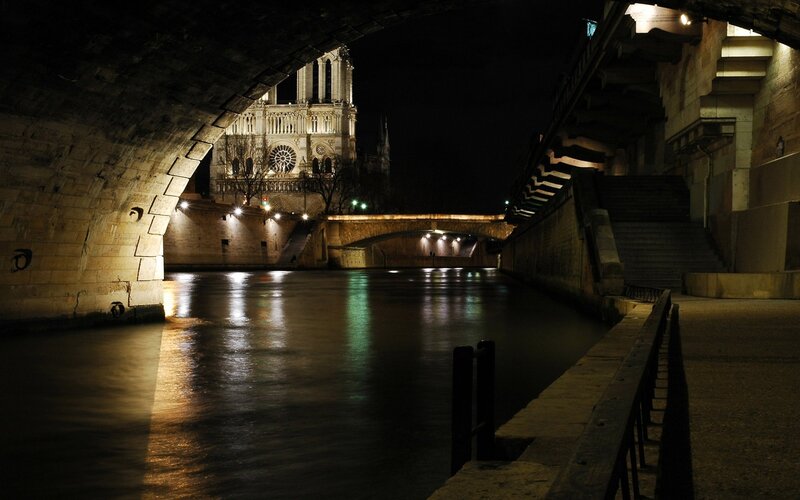 Notre-Dame at night from under a bridge