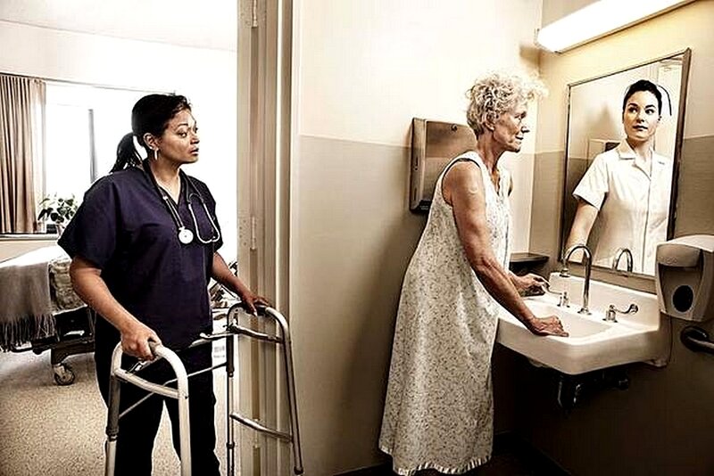 Nurse assisting patient at sink