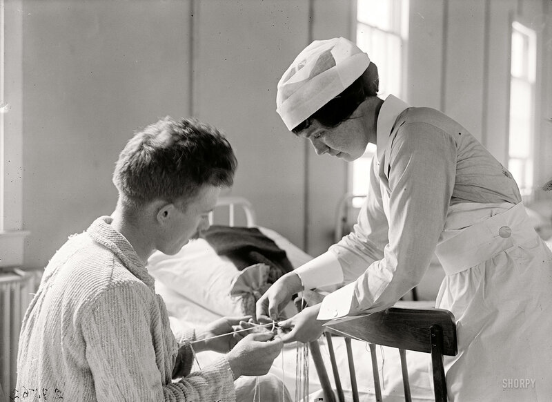Nurse assisting patient with knitting