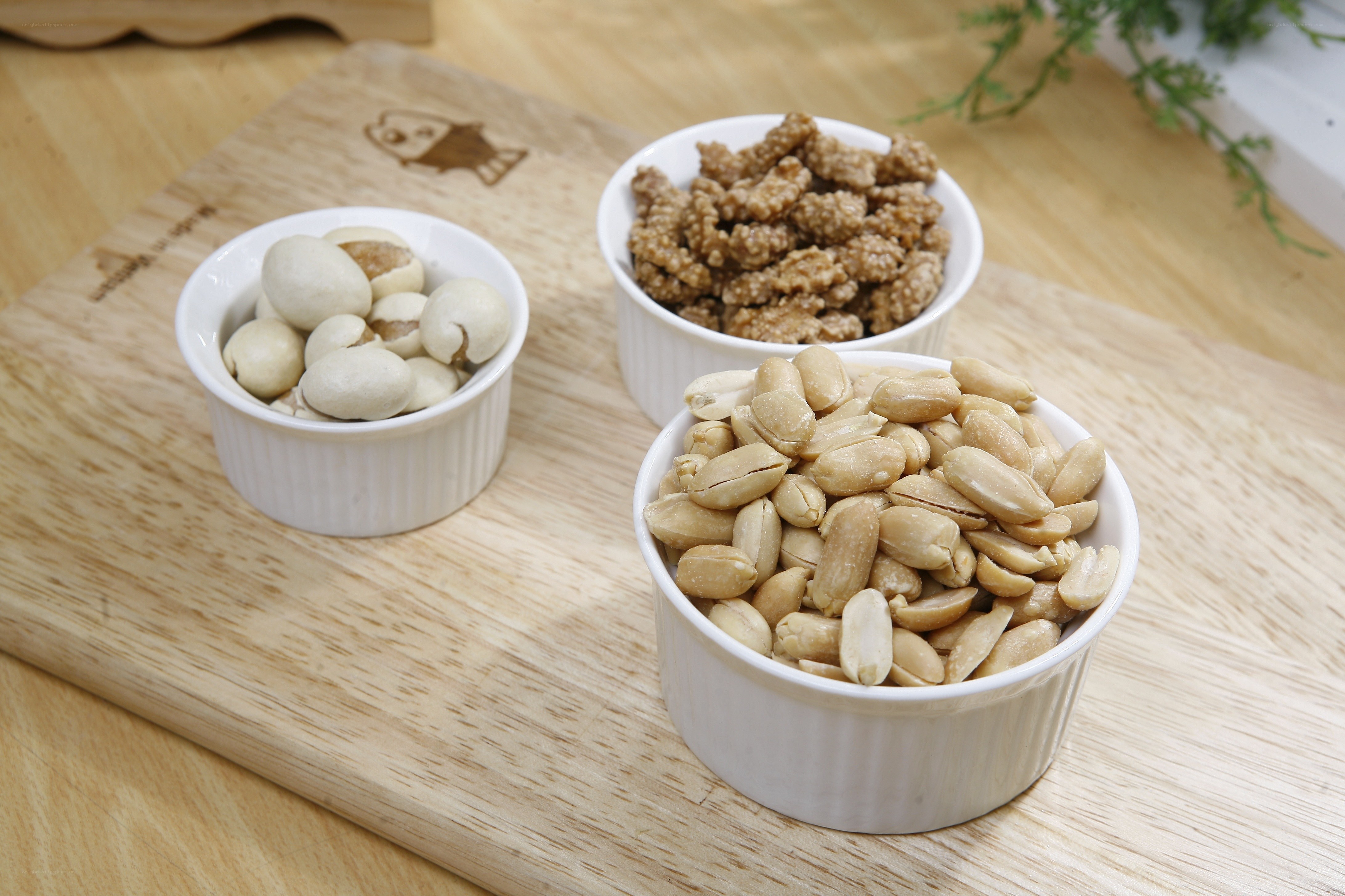 nuts in white bowls on wood