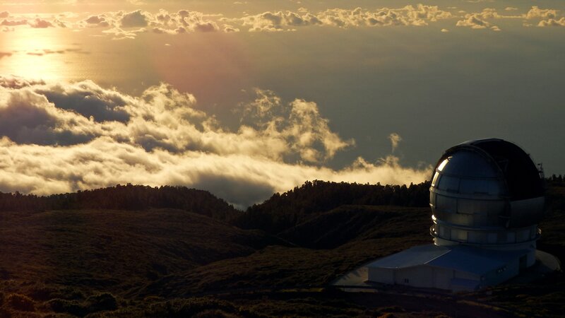 Observatory at sunset over clouds