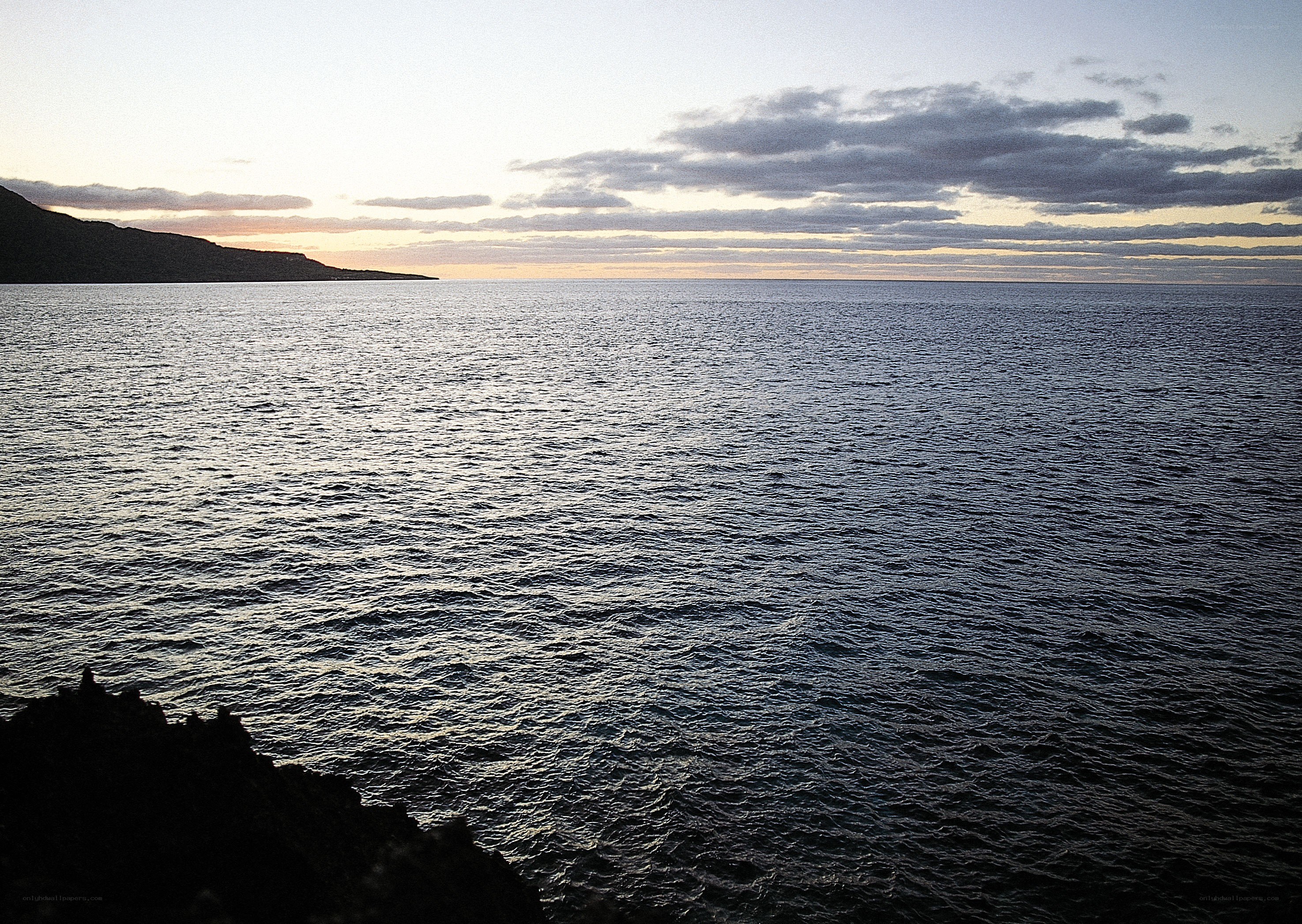 Ocean at dusk with distant land