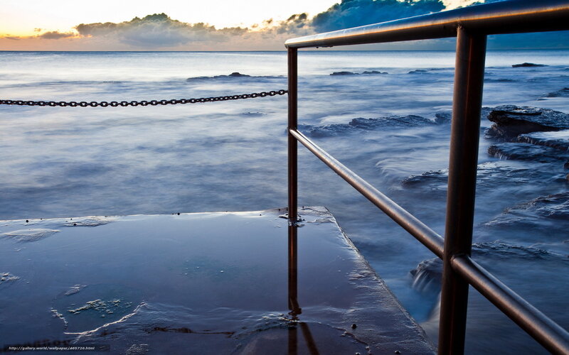 Ocean at sunset with railing