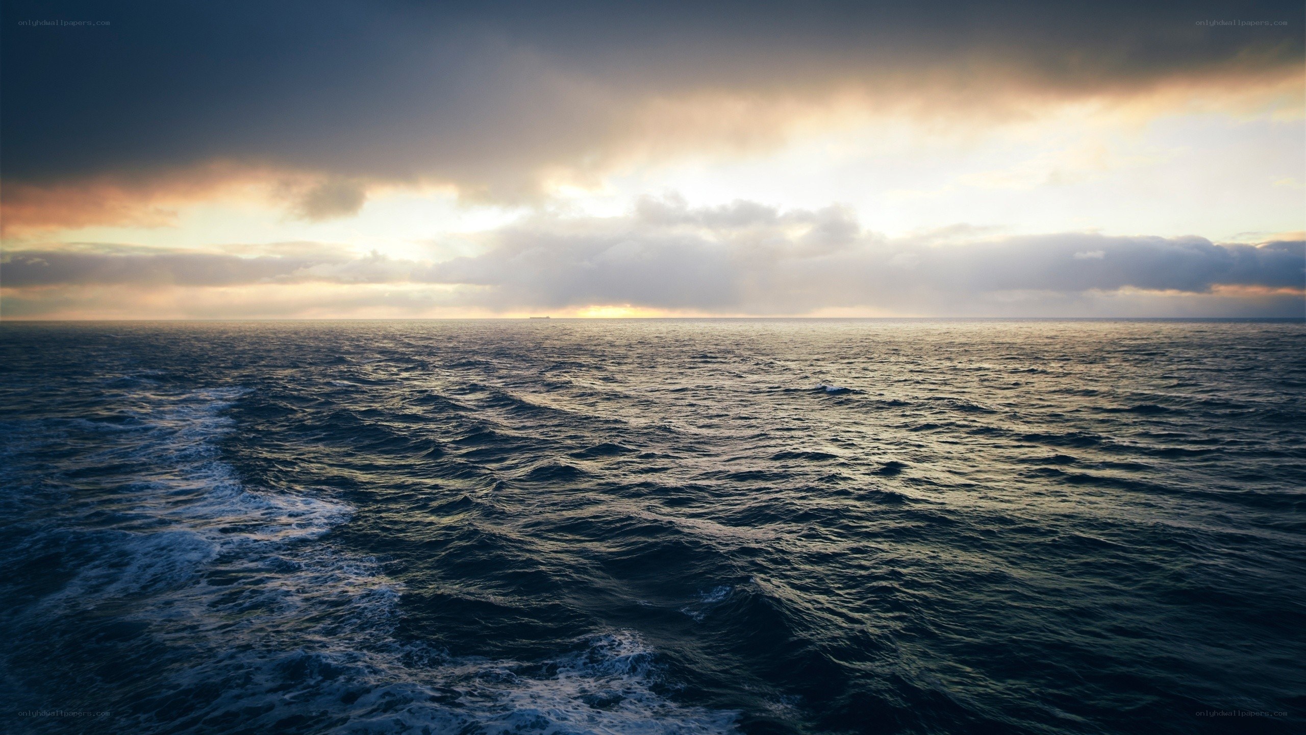 Ocean at sunset with ship wake