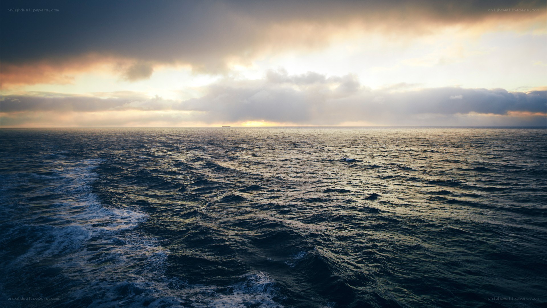 Ocean at sunset with ship wake