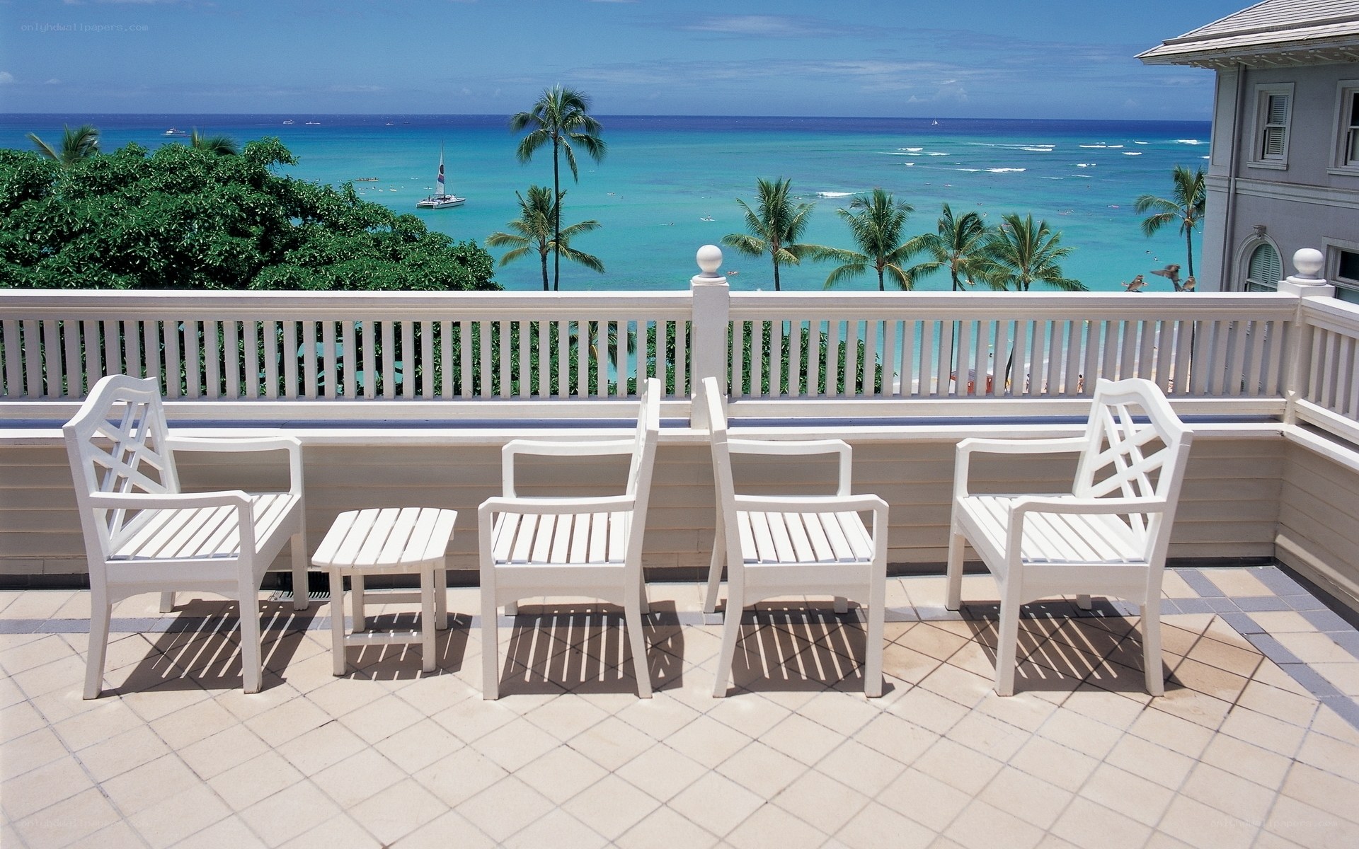 Ocean view balcony with white chairs
