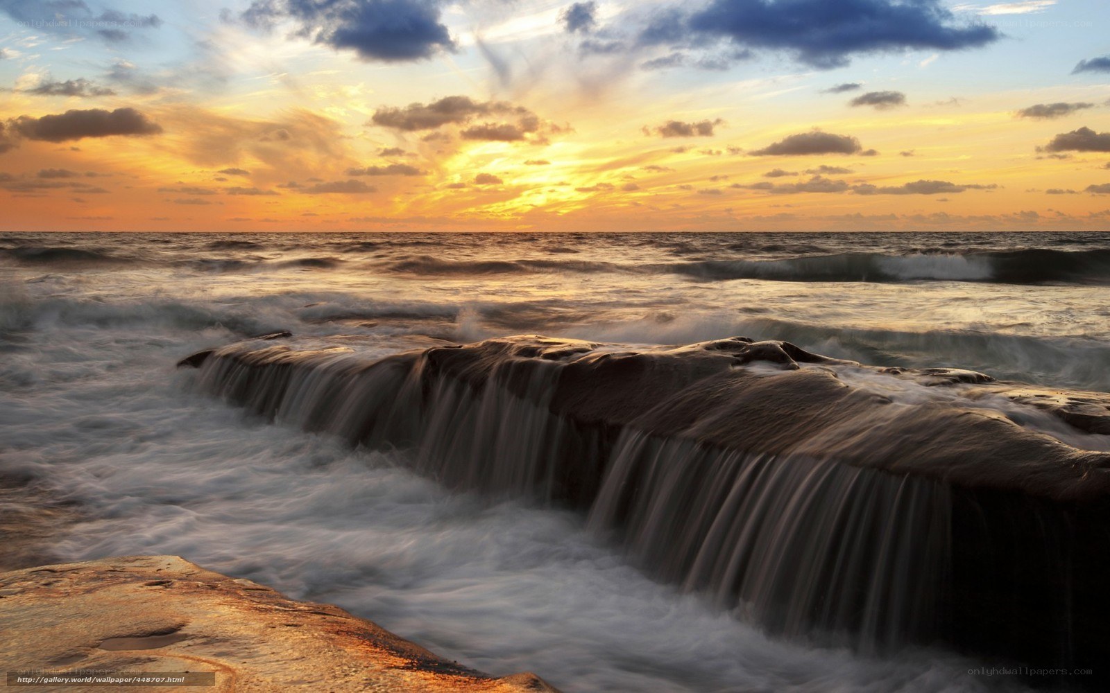 Ocean waterfall at sunset