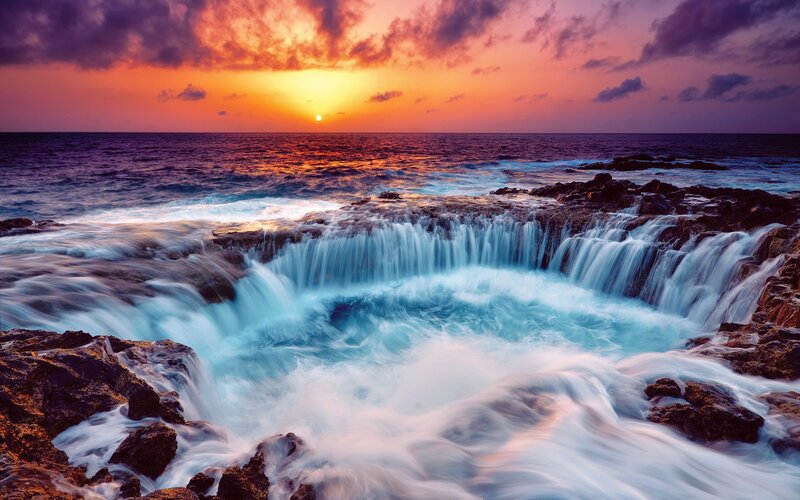 Ocean waterfall at sunset