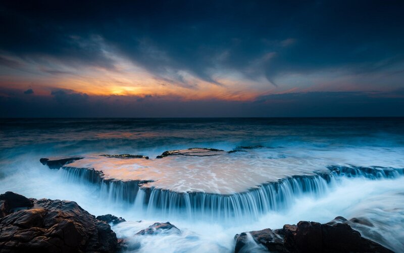 Ocean Waterfall at Sunset — Blue, Dramatic, Photograph, Rocks, Sky