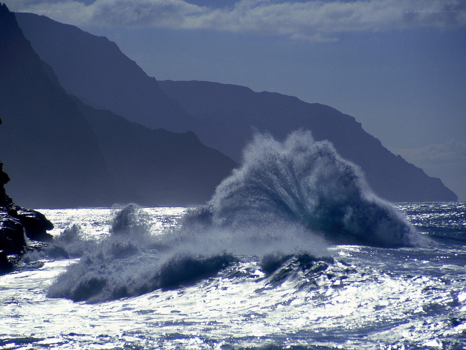 Ocean wave crashing against cliffs