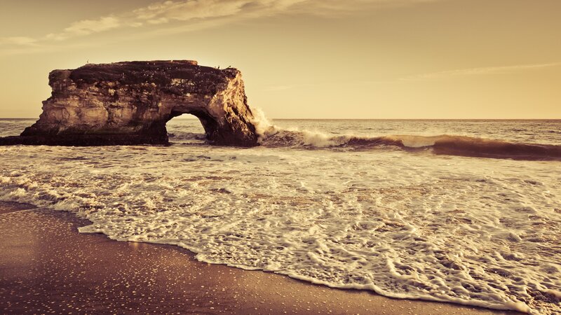 Ocean wave crashing at sea arch