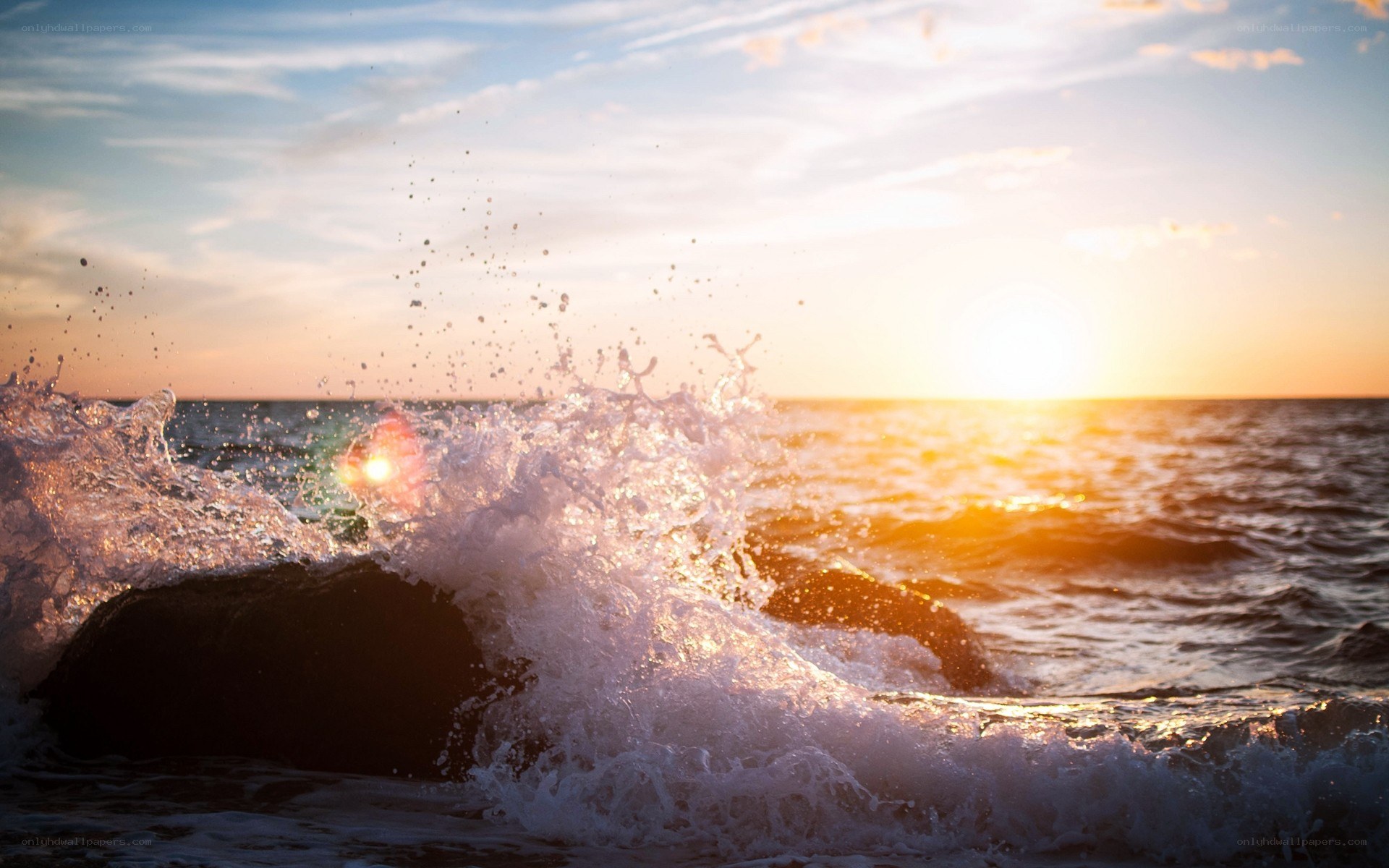 Ocean wave crashing at sunset