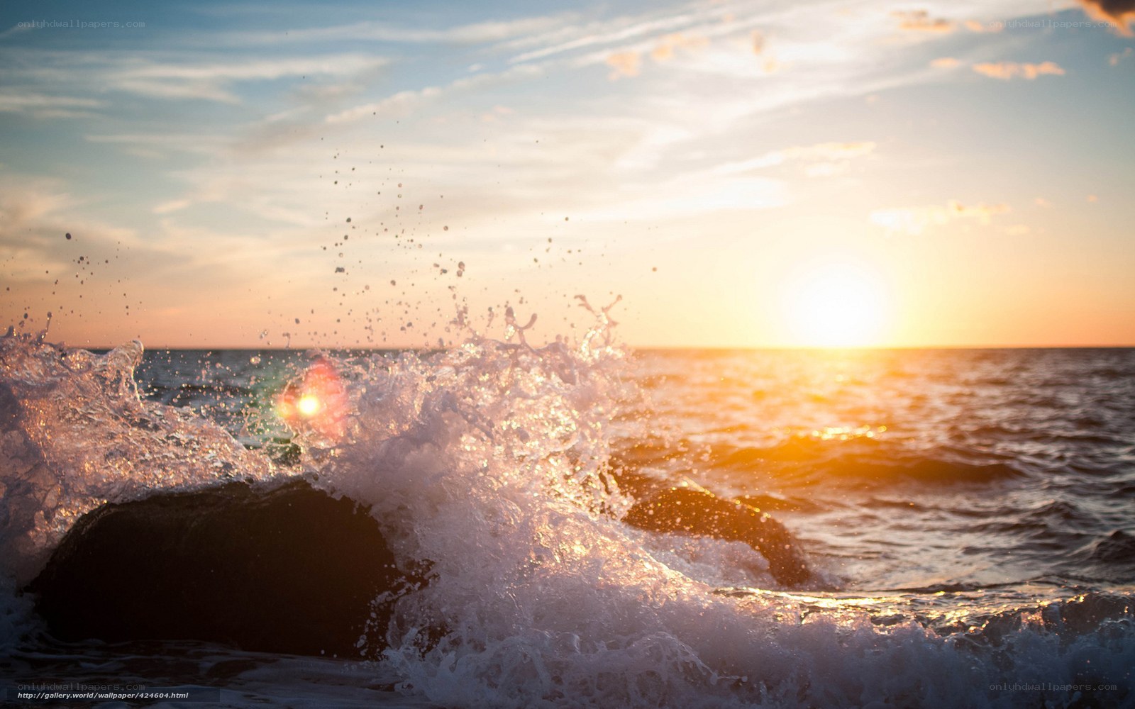 Ocean wave crashing at sunset