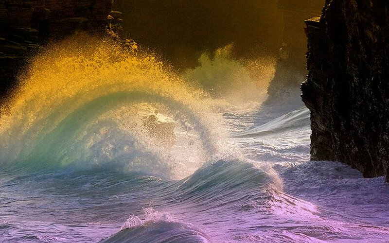 Ocean wave crashing between cliffs