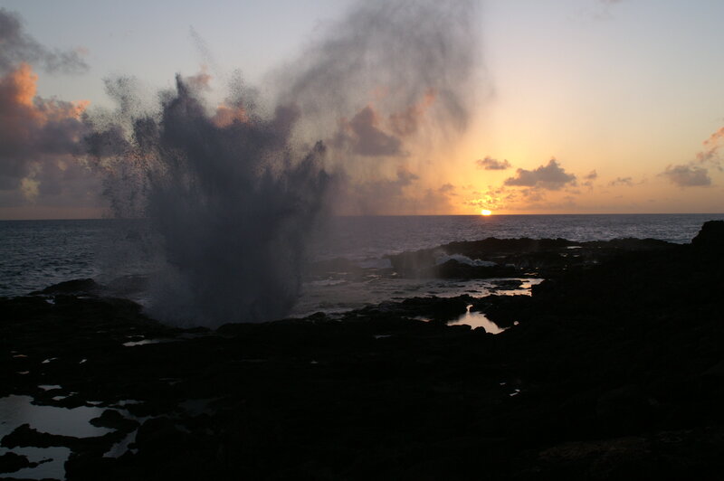 Ocean wave erupting at sunset