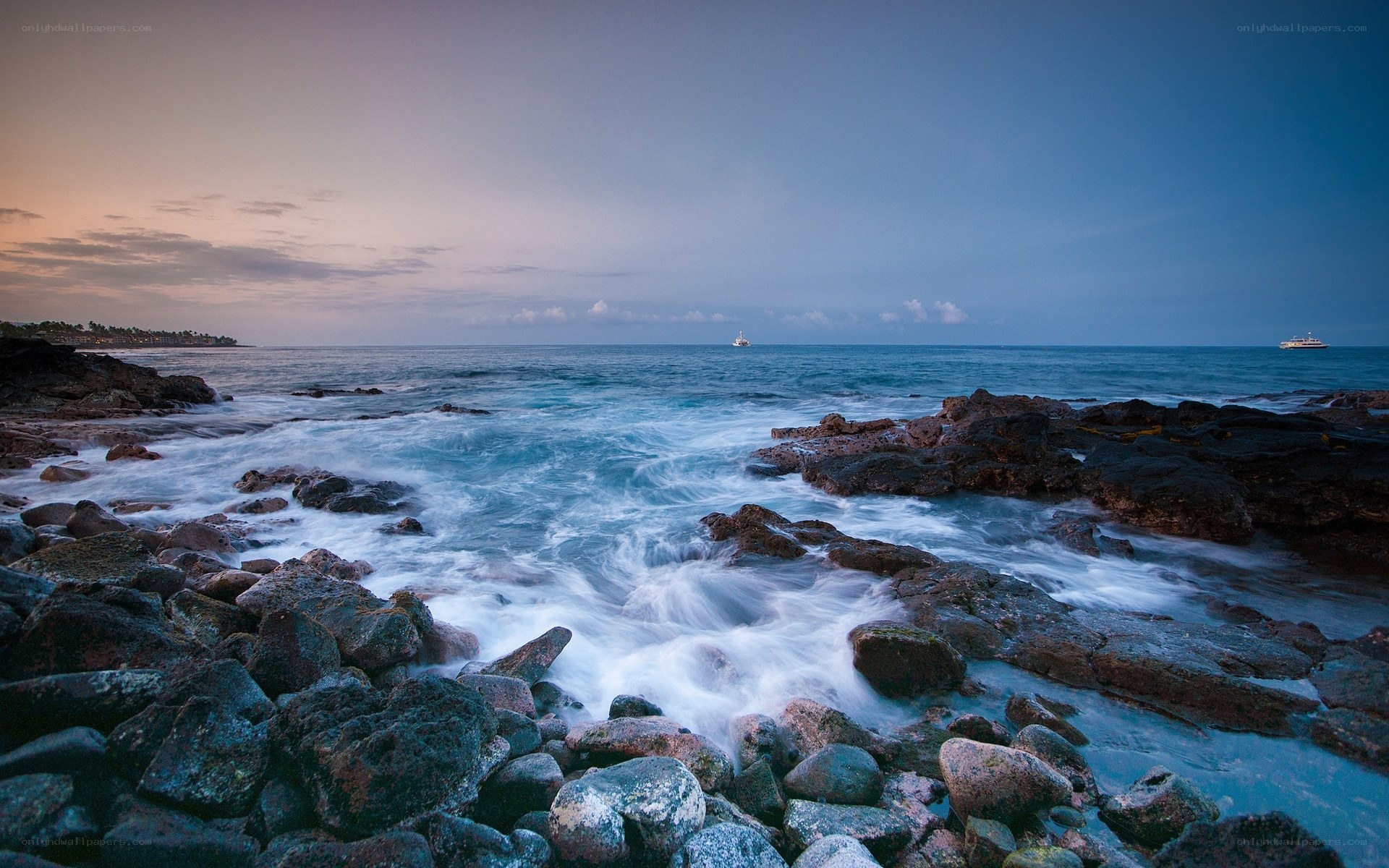 Ocean waves at dusk on rocky shore