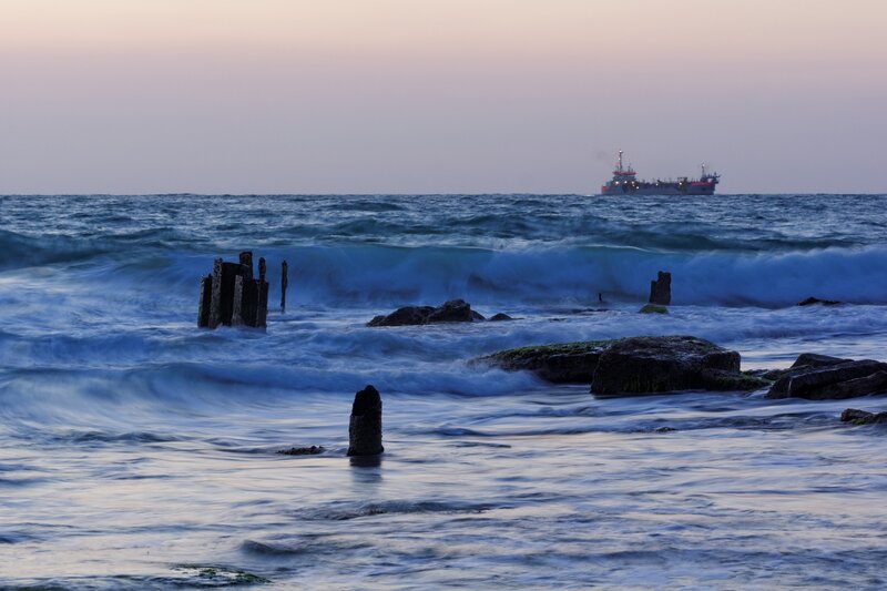Ocean waves at dusk with ship