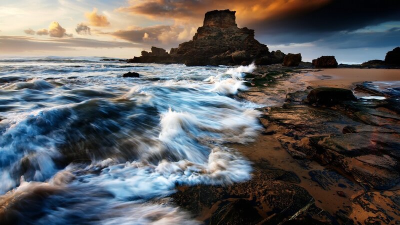 Ocean Waves at Rocky Shore — Blue, Dramatic, Sunset, Photograph, Rocks, Sand, Clouds