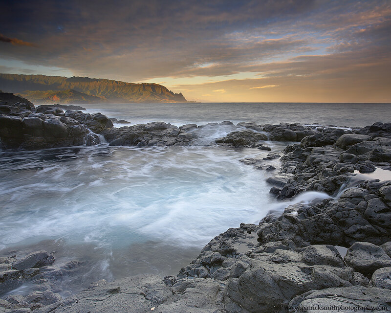 Ocean waves at sunset on rocky shore