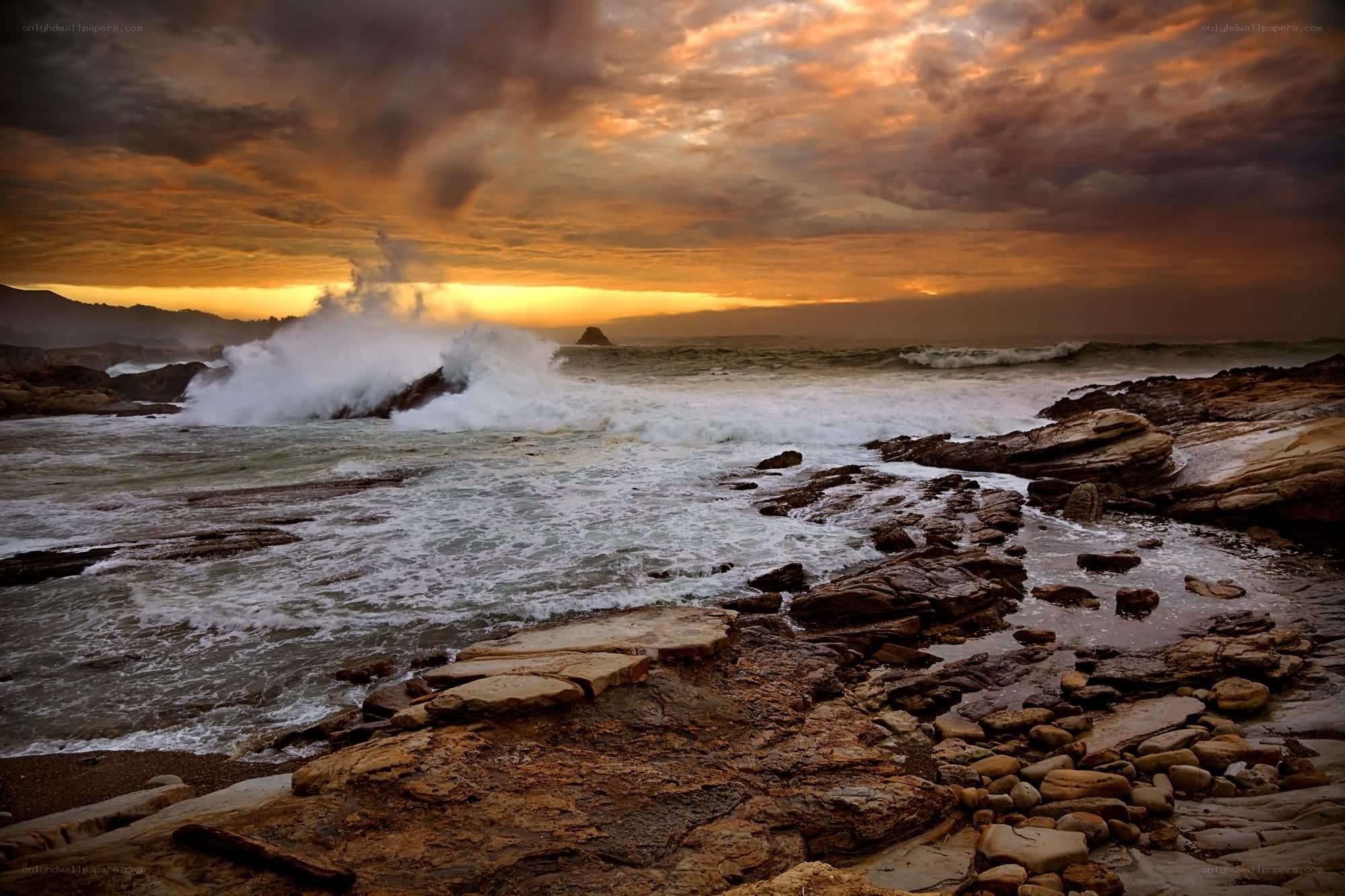 Ocean waves crashing at sunset