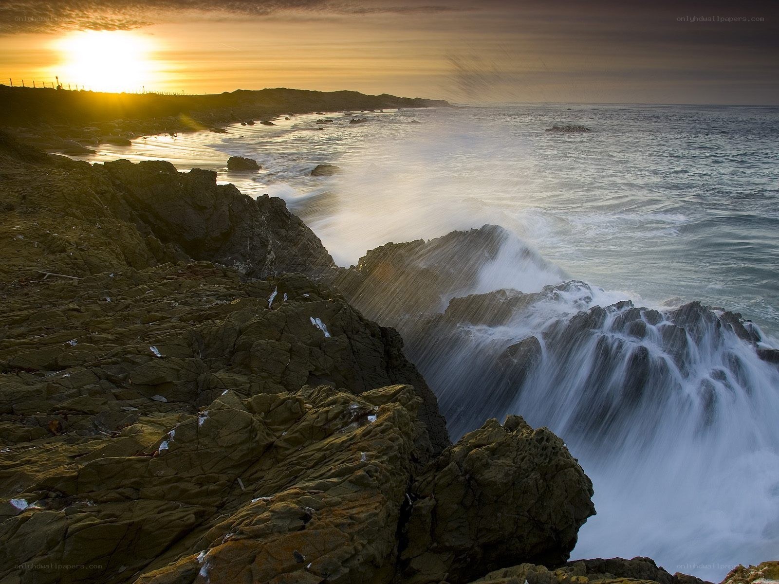 Ocean waves crashing at sunset