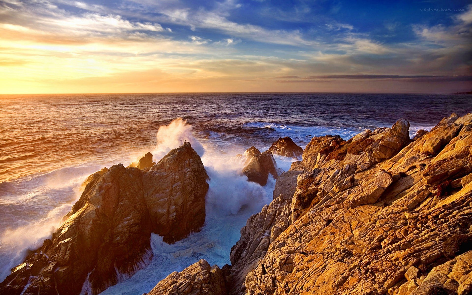Ocean waves crashing on rocks at sunset
