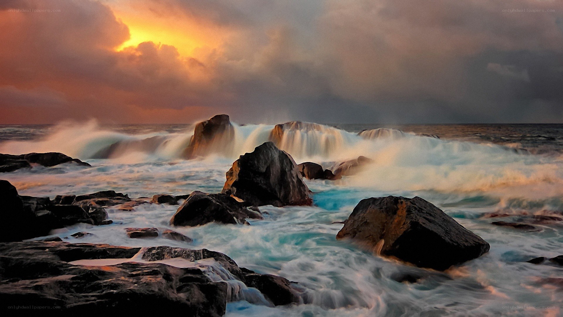 Ocean waves crashing on rocks at sunset