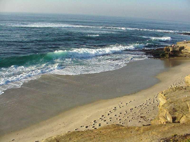 Ocean Waves on Sandy Beach — Blue, Calm, Afternoon, Photograph, Sand, Rocks, People