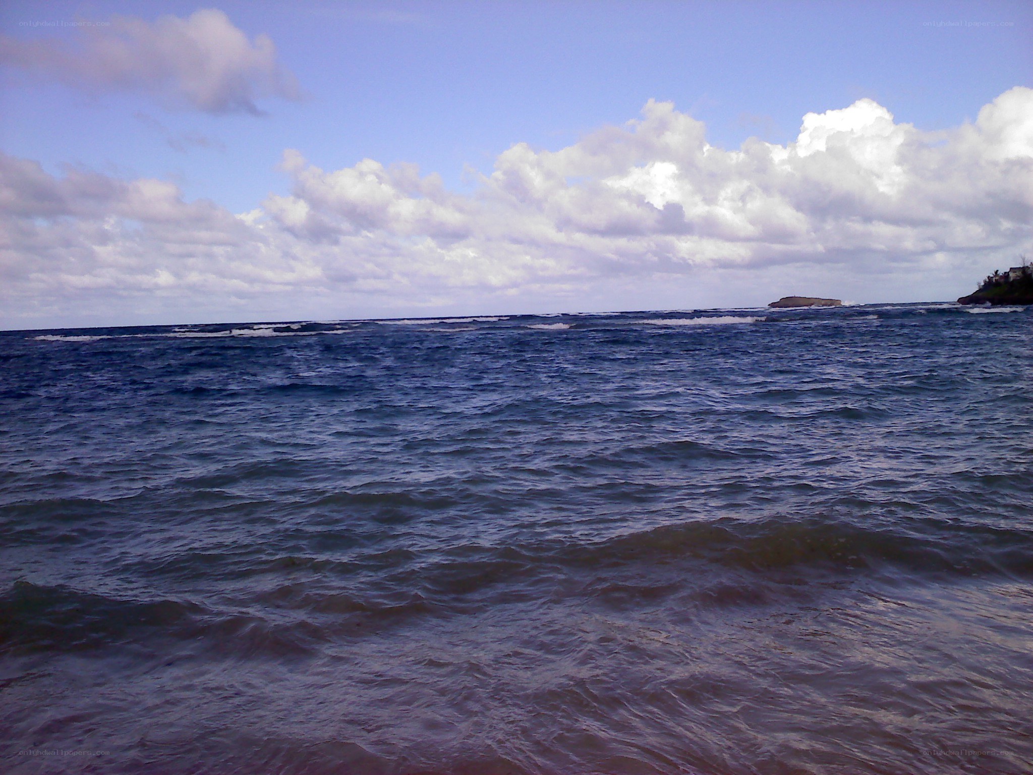 Ocean waves under cloudy sky