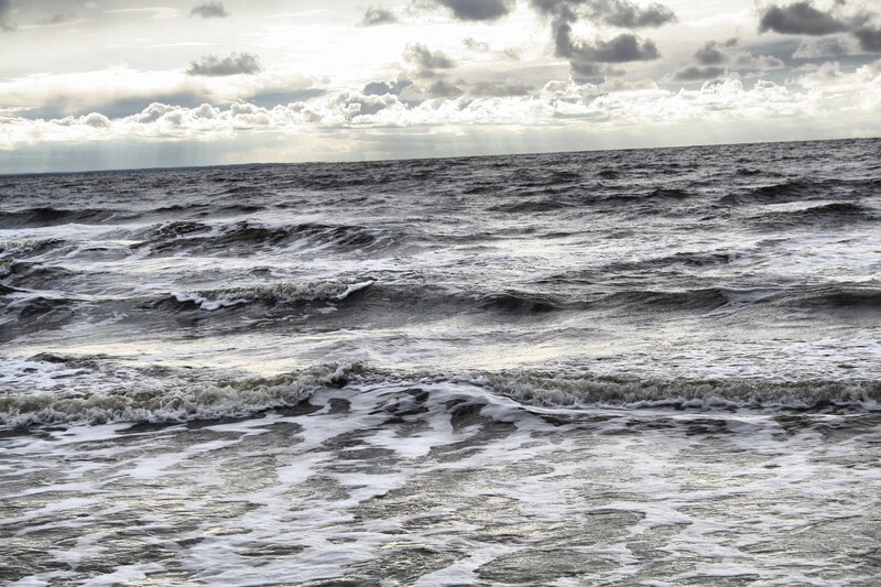 Ocean waves under cloudy sky