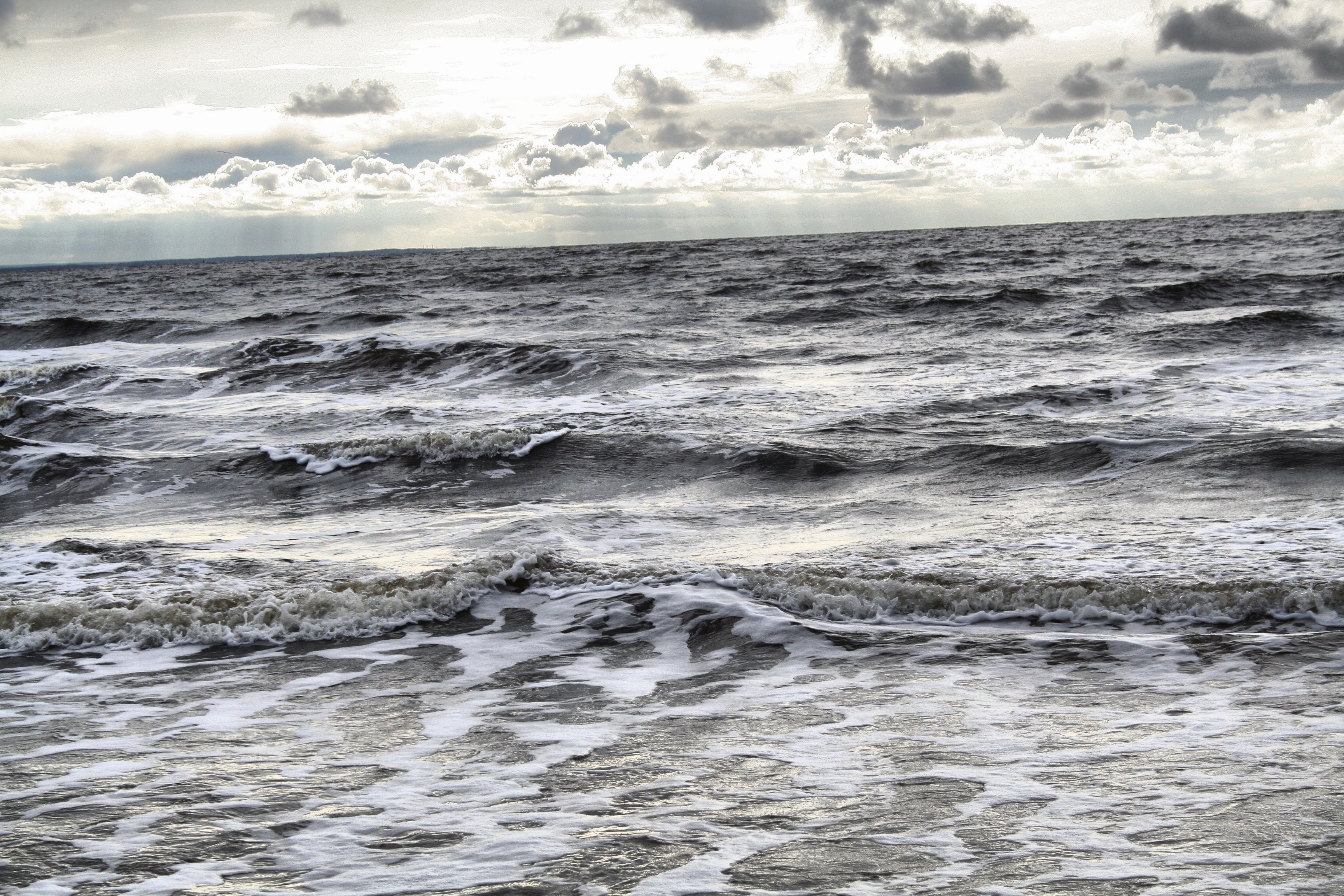 Ocean waves under cloudy sky