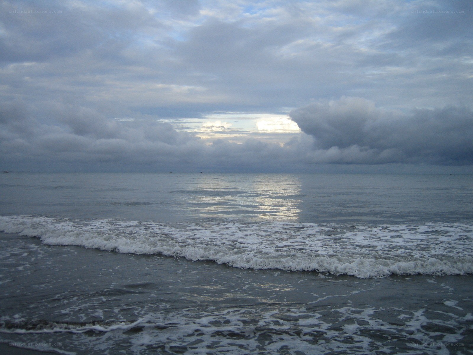 Ocean waves under cloudy sky