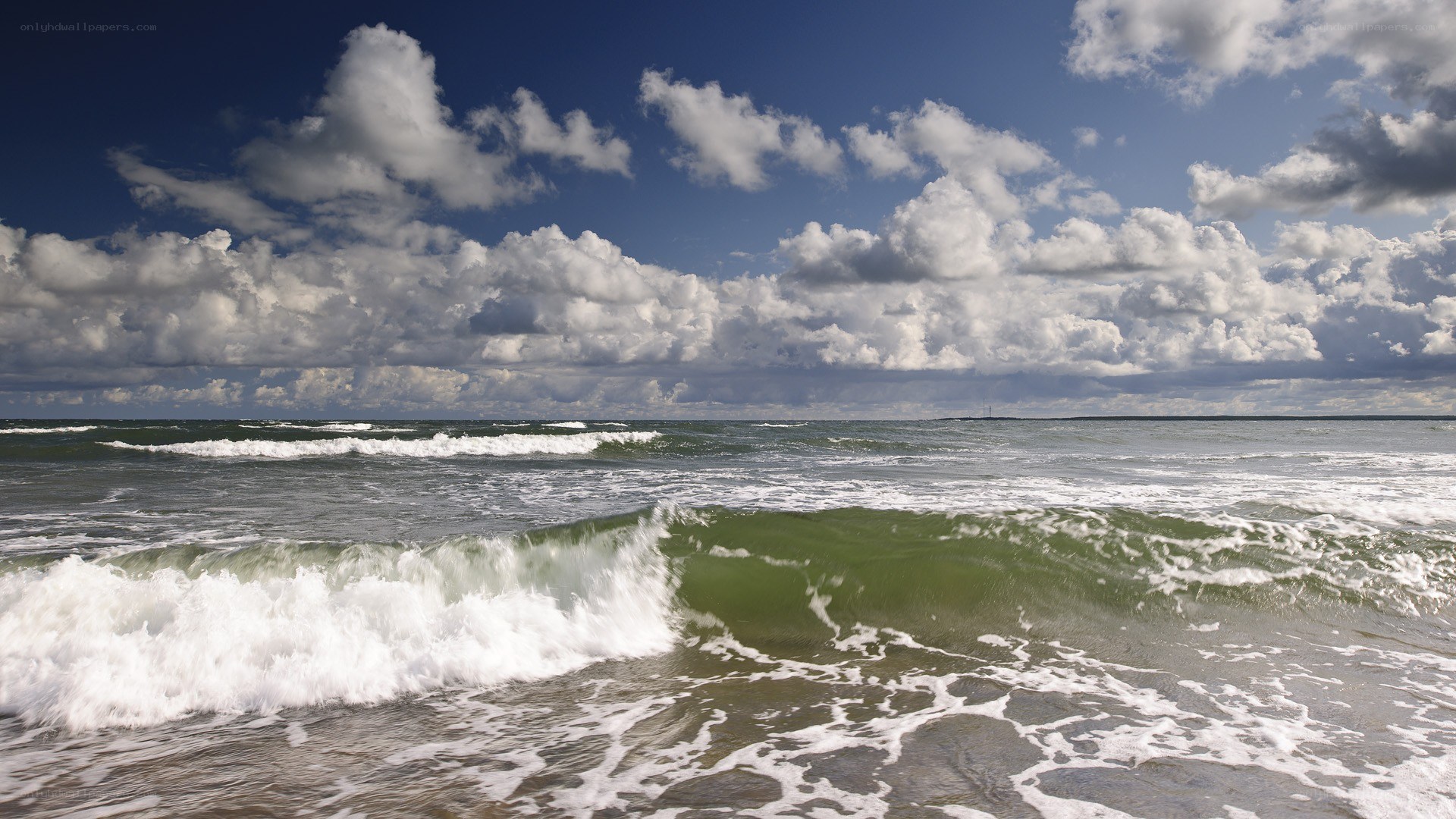 Ocean waves under cloudy sky