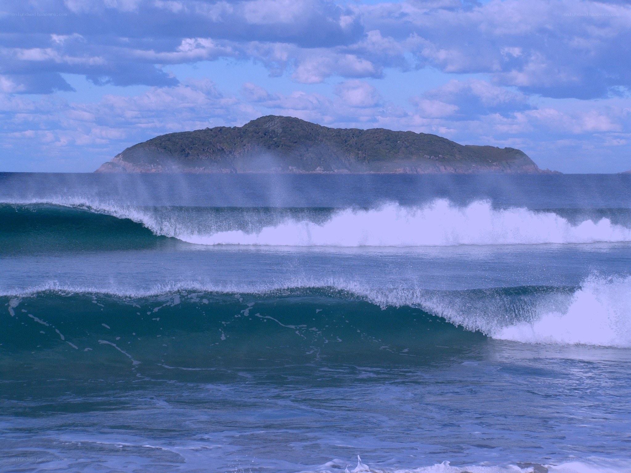 Ocean waves with island in background