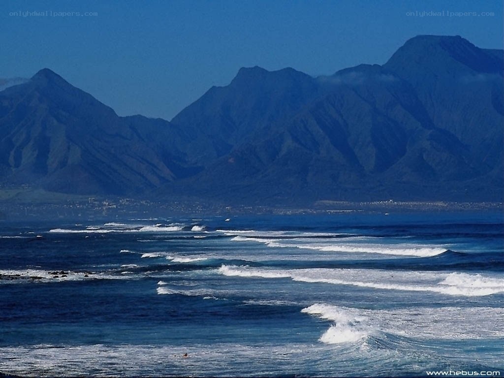 Ocean waves with mountains in background