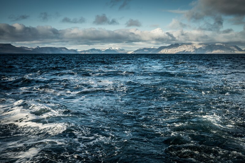 Ocean waves with mountains in distance