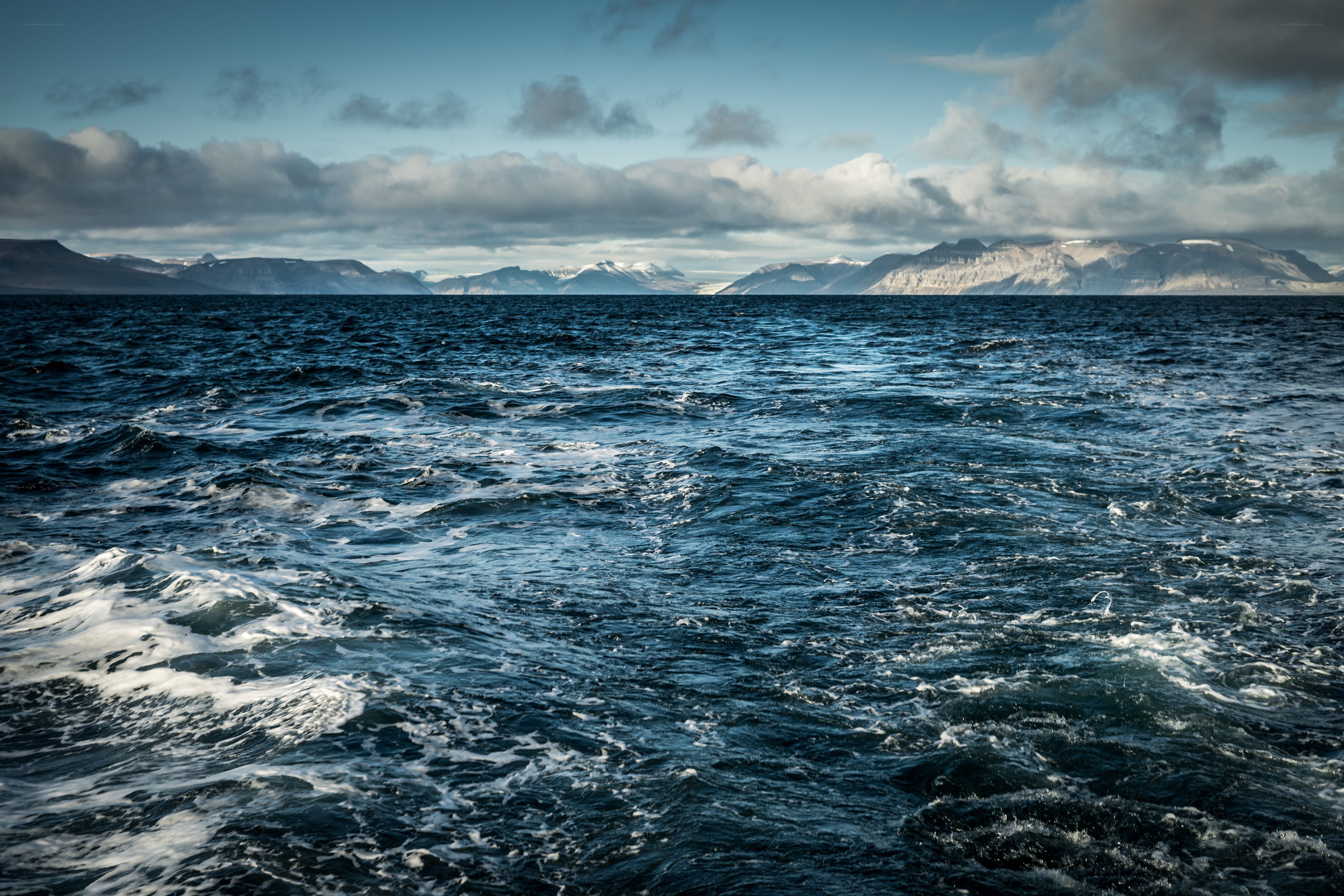 Ocean waves with mountains in distance