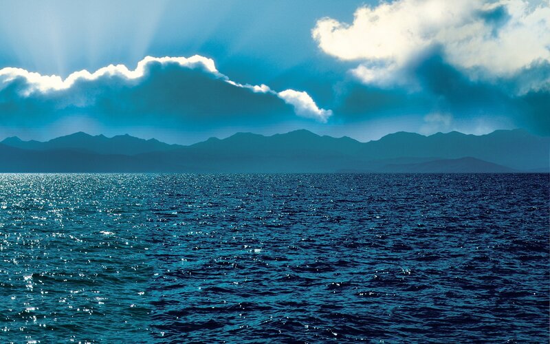 Ocean with Distant Mountains — Blue, Dramatic, Afternoon, Photograph, Clouds, Sunlight