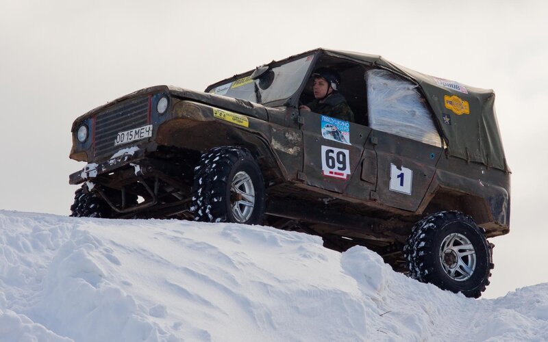 Off-road vehicle on snowy hill