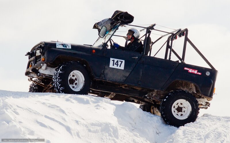 Off-road vehicle on snowy hill