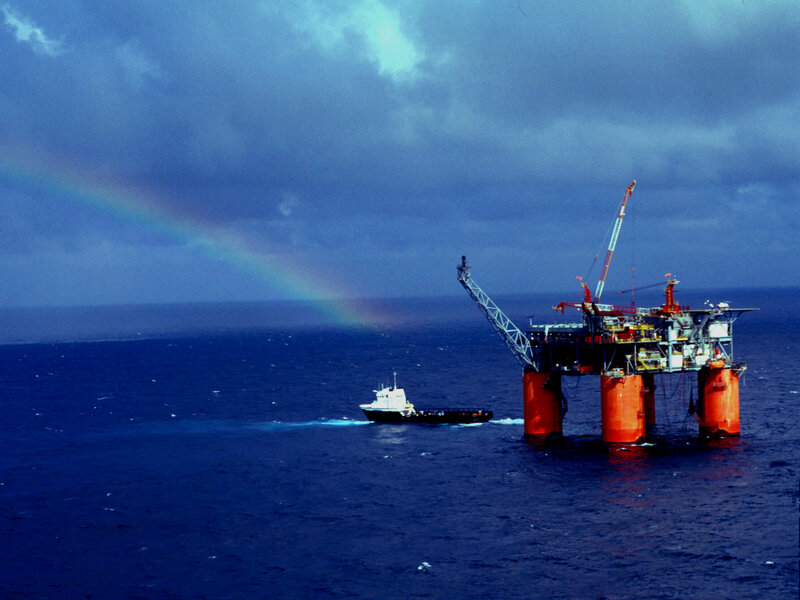 Oil rig with rainbow in ocean