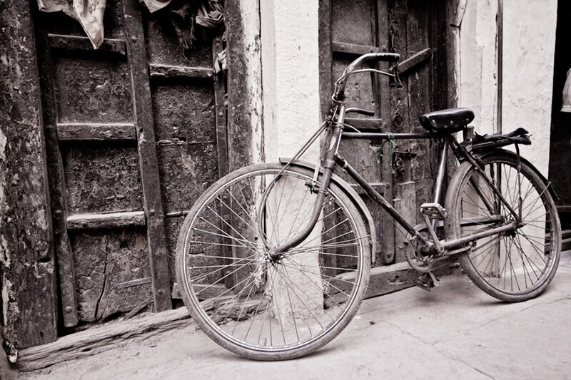 Old bicycle by a wooden door