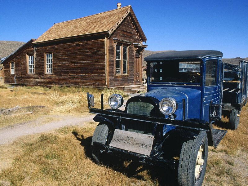 Old blue truck in front of wooden building