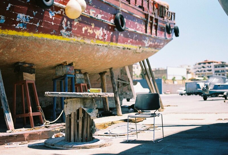 Old boat on land with table and chair